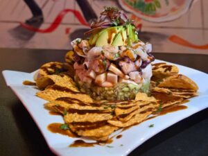 Plate stacked beautifully of toppings piled on bed of nacho chips for article The Lucky 7 - Hottest New Restaurants in Tucson for newcomers moving to Tucson.