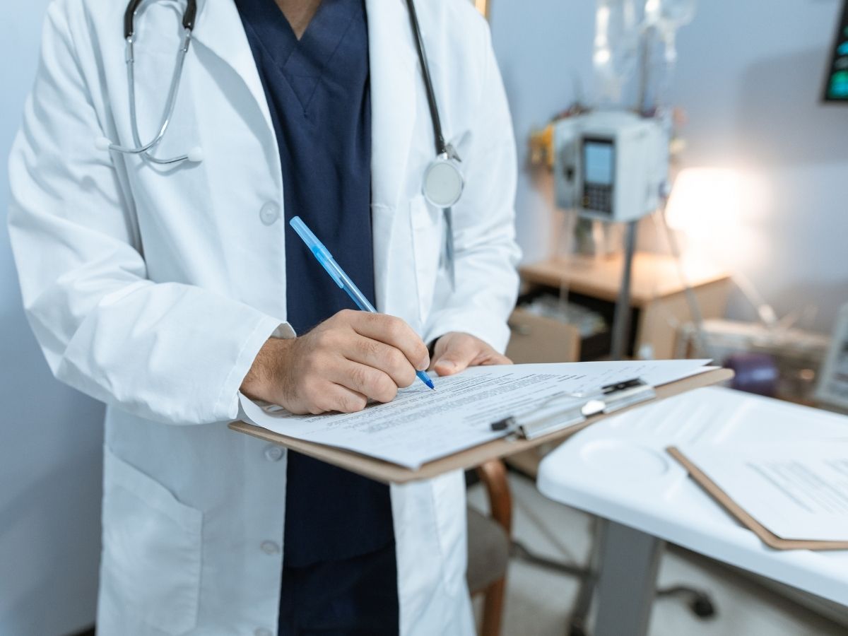 Closeup of doctor writing notes on a piece of paper on a clipboard for article Finding a New Doctor in Tucson for newcomers moving to Tucson.