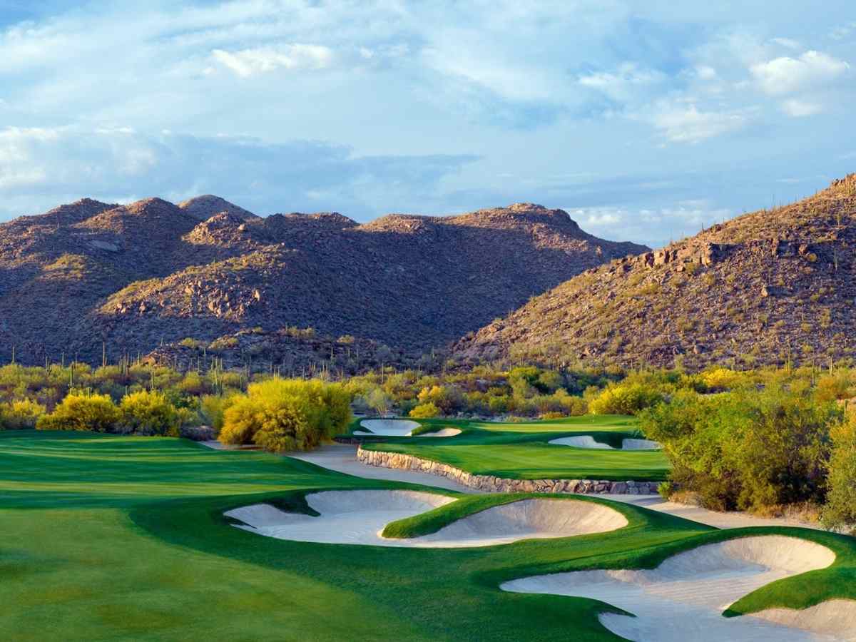 Photo of The Gallery at Dove Mountain golf course with beautiful sand traps and mountains in the background for article Top 11 Golf Course Communities in Tucson for newcomers moving to Tucson.