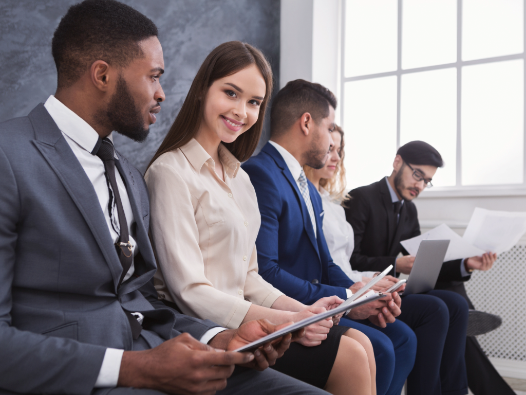 recent graduates sitting and waiting to be called for a job interview.