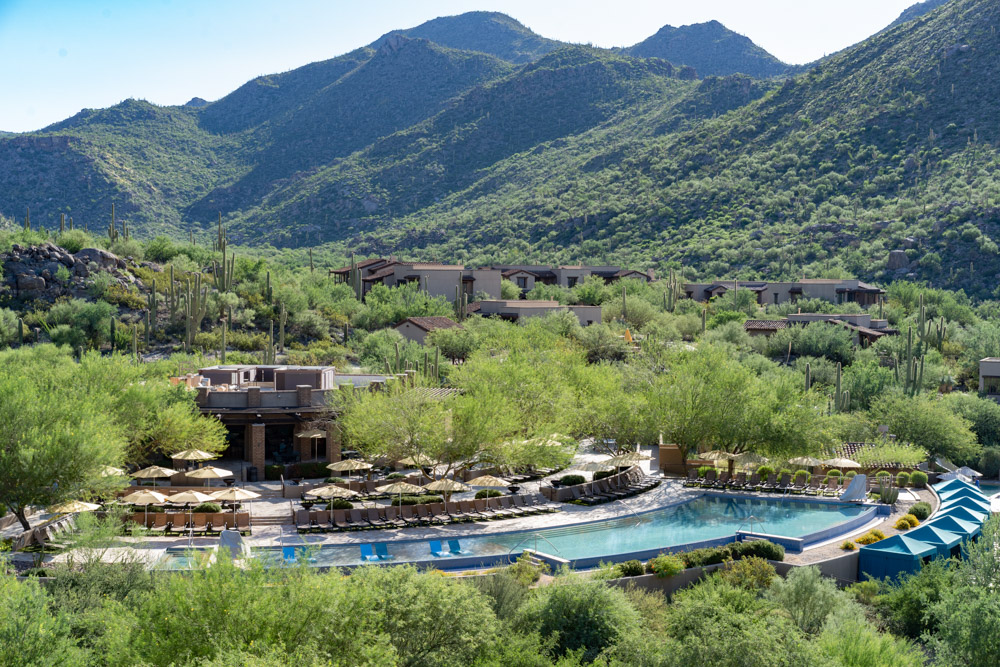 Resort style pool tucked away in the Arizona landscape with mountains in background for article Play Hard, Live Fully at Dove Mountain for newcomers moving to Tucson.