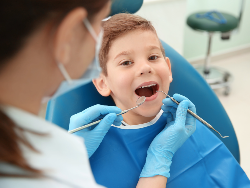 Young boy sitting in Dental chair with slight smile and mouth open for article on Discover 6 Trusted Dentists in Tucson.