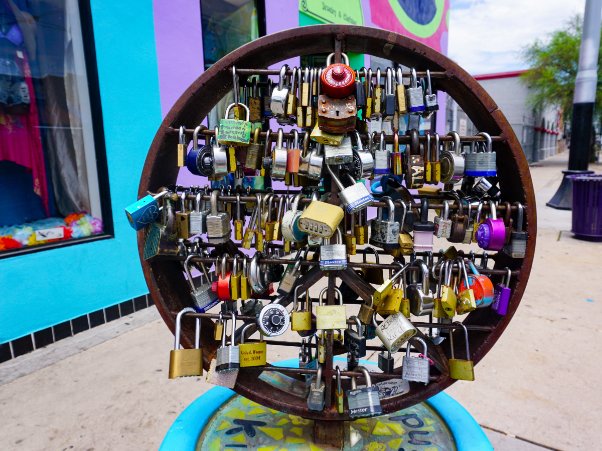 Round sculpture with locks attached to it in middle of sidewalk for article Discovering the Most Unique Neighborhood in Tucson for newcomers moving to Tucson.