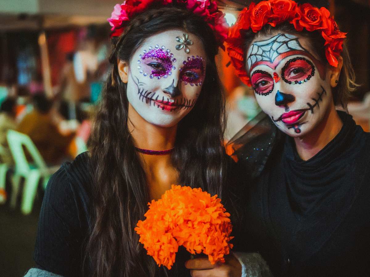 2 Women with faces painted white with skeleton features for All Souls Weekend in Tucson for article Quirky Things to Do in Tucson for newcomers moving to Tucson.